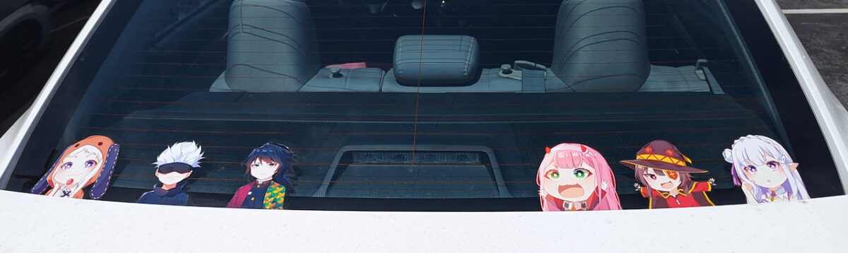 a photograph of a line-up of six anime character stickers in the rear window of a car